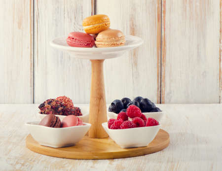 Sweet dessert - Colorful macaroons, fresh berries and candiesの写真素材