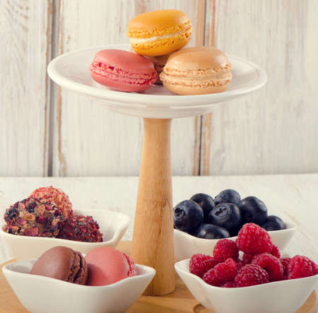 Sweet dessert - Colorful macaroons, fresh berries and candiesの写真素材