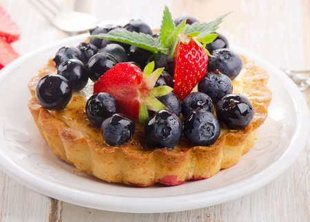 Fresh berry tart on a white plate. Selective focusの写真素材