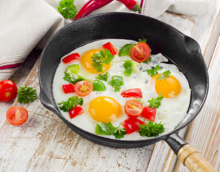 Fried eggs in a pan with vegetables. Selective focusの写真素材