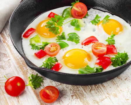 Fried eggs in a pan with vegetables. Selective focusの写真素材