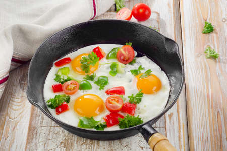 Fried eggs in a pan with vegetables. Selective focusの写真素材