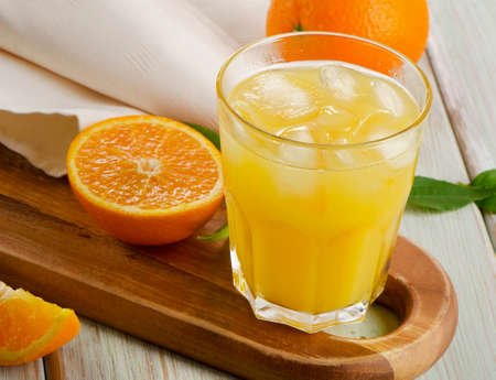 Glass of  orange juice with sliced orange  on wooden table. Selective focusの写真素材