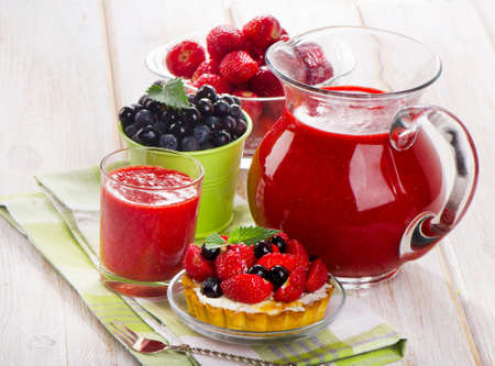 Strawberry smoothie with sweet cake and fresh berries on a wooden table . Selective focusの写真素材