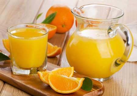 Glass and jug of  orange juice with sliced orange. Selective focusの写真素材