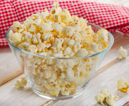 Popcorn in glass bowl on a wooden table. Selective focusの写真素材