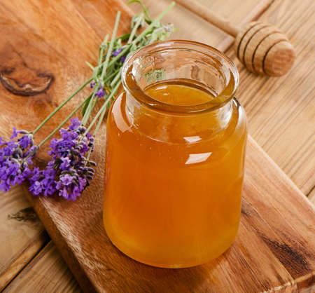 Glass jar of honey with wooden stick. Selective focusの写真素材