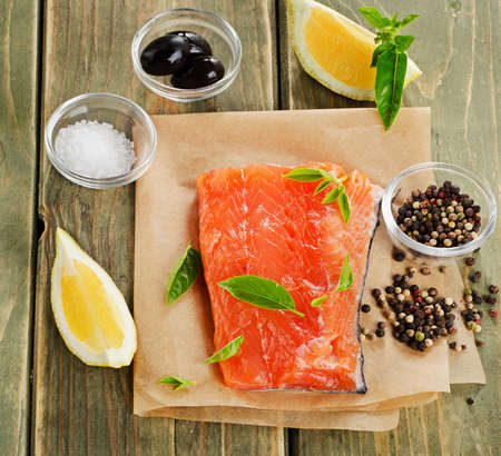 Salmon on a wooden board with lemon and herbs .の写真素材