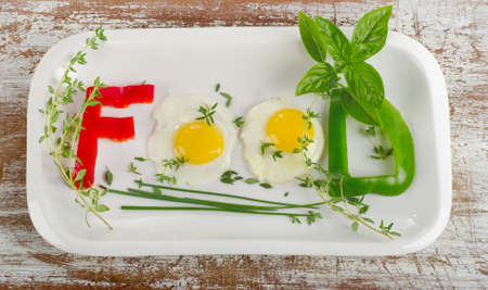 Fresh vegetables and eggs with herbs  on a white plateの写真素材
