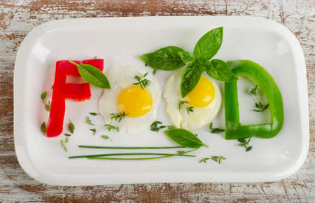 Fresh vegetables and eggs with herbs  on a white plateの写真素材