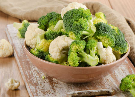 Fresh green broccoli and  cauliflower on a  wooden table. Selective focusの写真素材