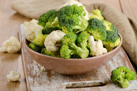 Fresh green broccoli and  cauliflower on a  wooden table. Selective focusの写真素材