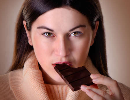 Young beautiful woman with  a chocolate barの写真素材