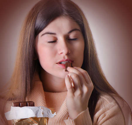 Young beautiful woman with  a chocolate barの写真素材
