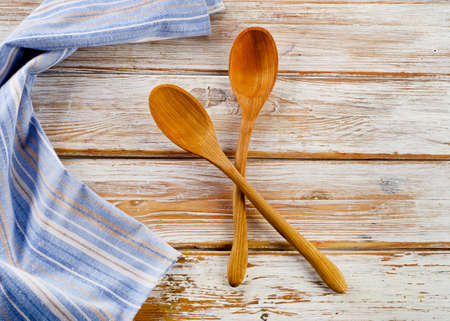 Blue napkin with wooden spoons on a white wooden tableの写真素材