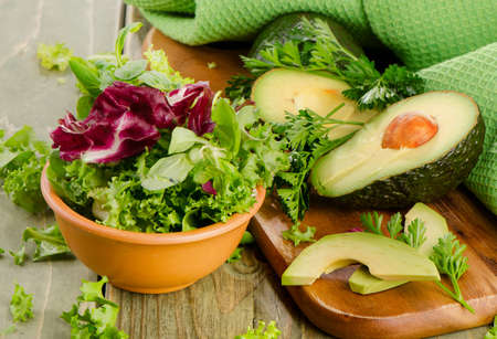 Lettuce salad and fresh avocado on a wooden table. Selective focusの写真素材