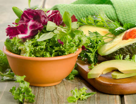 Lettuce salad and fresh avocado on a wooden table. Selective focusの写真素材
