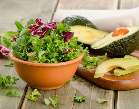 Lettuce salad and fresh avocado on a wooden table. Selective focusの写真素材
