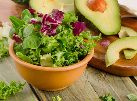Lettuce salad and fresh avocado on a wooden table. Selective focusの写真素材