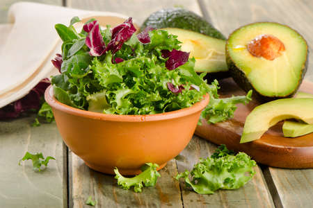 Lettuce salad and fresh avocado on a wooden table. Selective focusの写真素材