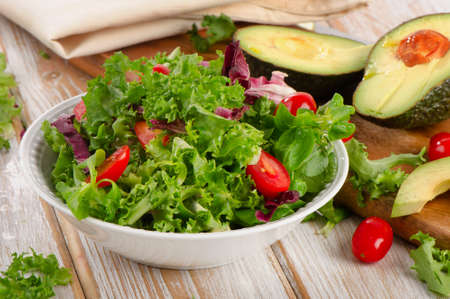 Lettuce salad and fresh avocado on a wooden table. Selective focusの写真素材