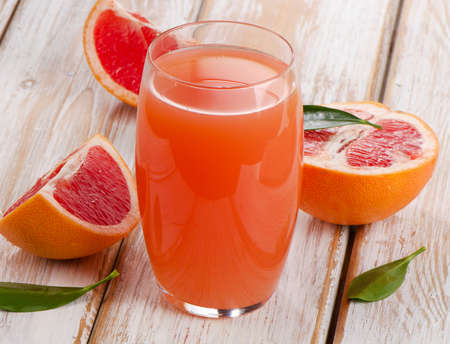 Grapefruit juice and  grapefruits on a wooden table. Selective focusの写真素材
