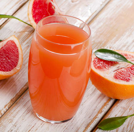 Fresh grapefruit juice  on a wooden table. Selective focusの写真素材