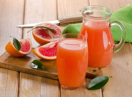 Grapefruit juice and  grapefruits on a wooden table. Selective focusの写真素材