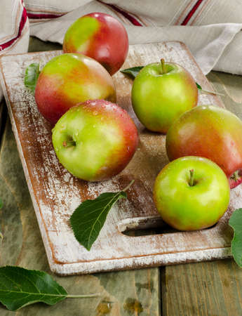 Apples with water drops on a wooden table.の写真素材