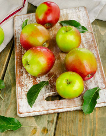 Apples with water drops on a wooden table.の写真素材