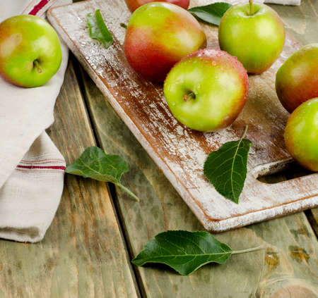 Apples with water drops on a wooden table.の写真素材