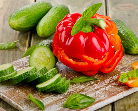 Red  paprika and cucumbers  on a wooden tableの写真素材