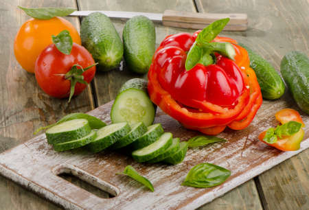 Red  paprika and cucumbers  on a wooden tableの写真素材