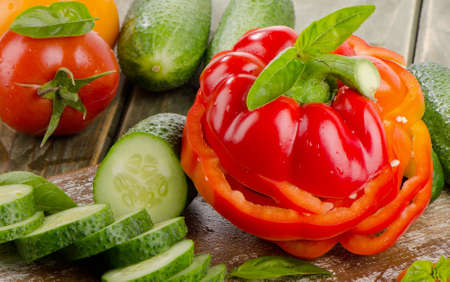 Red  paprika and cucumbers  on a wooden tableの写真素材