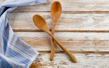 Blue napkin with wooden spoons on a white wooden tableの写真素材