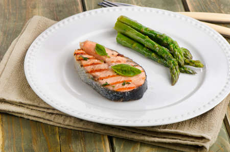 Grilled salmon with green asparagus  and  herbs on white plate. Selective focusの写真素材