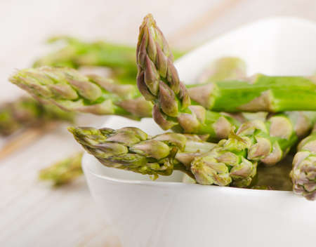 Bunch of fresh asparagus in white bowl. Selective focusの写真素材