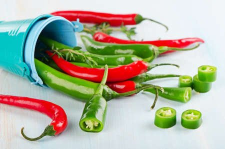 Red and green Chili Peppers on a wooden table.  Selective focusの写真素材
