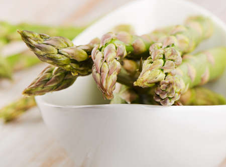 Bunch of fresh asparagus in a white bowl. Selective focusの写真素材