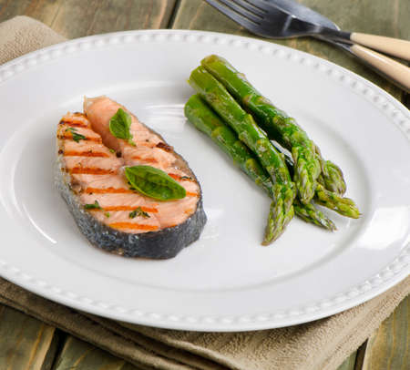 Salmon with green asparagus  and  herbs on white plate. Selective focusの写真素材