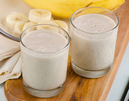 Healthy banana smoothie on  wooden table. Selective focus の写真素材