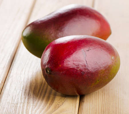 Two Fresh mango  on a  wooden background . Selective focusの写真素材