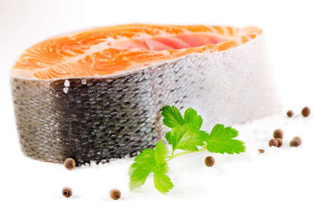 Fresh salmon  steak with salt and peppers isolated on a white. Selective focusの写真素材