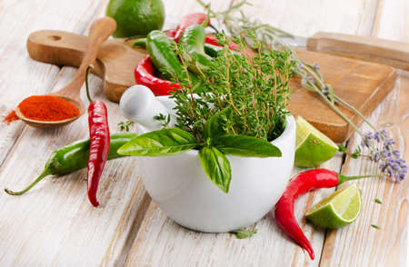 Fresh herbs and red chili peppers on wooden table. Selective focusの写真素材