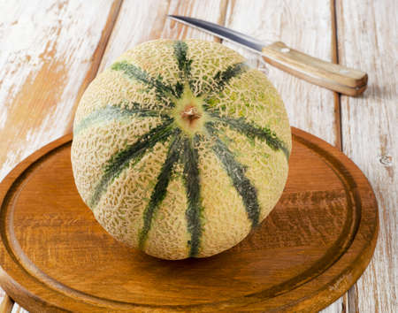 Whole melon  on a wooden table. Selective focusの写真素材