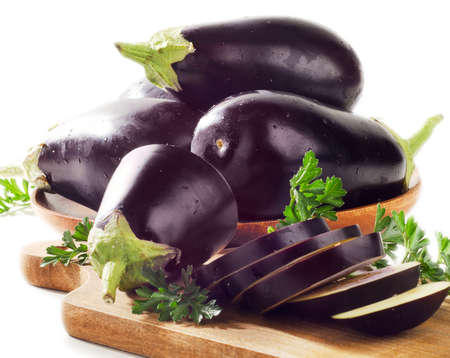 Fresh eggplants on a wooden border isolated on white background . Selective focusの写真素材