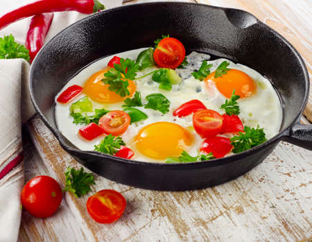 Healthy traditional breakfast - Fried eggs with vegetables  in  pan. Selective focusの写真素材