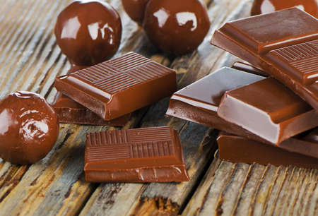 Broken chocolate bar and candies  on a wooden table. Selective focusの写真素材