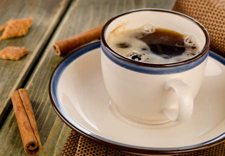 Cup of coffee and cinnamon on a wooden table. Selective focusの写真素材