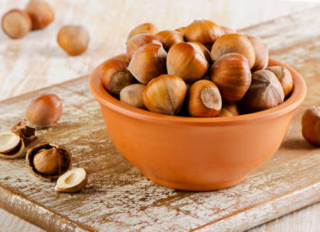 Hazelnuts on old wooden boardの写真素材